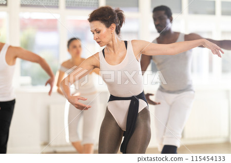 Graceful woman leading ballet class with adult amateur dancers 115454133