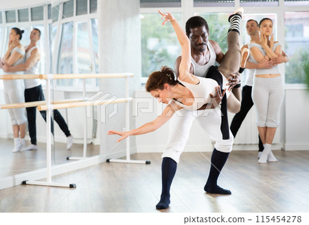 Ballet duo mastering complex dance dips and lifts in studio Ballet duo mastering complex dance dips and lifts in studio 115454278