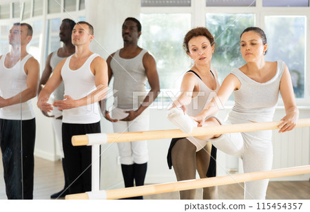 Ballet pose grand batman - ballet troupe of different nationalities at choreography lesson 115454357