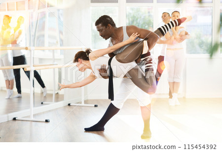 African American male dancer supporting ballerina in graceful dip 115454392