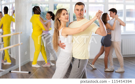 Man and young woman dancing waltz in couple during lesson at studio Man and young woman dancing waltz in couple during lesson at studio 115454394