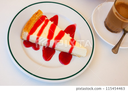 Classic cheesecake served with sweet berry sauce 115454463