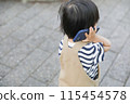 A child walking and using a smartphone 115454578