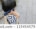 A child walking and using a smartphone 115454579