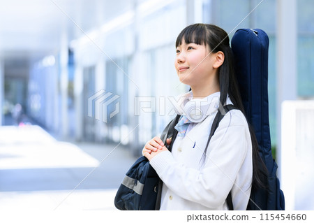 High school girl carrying a guitar 115454660