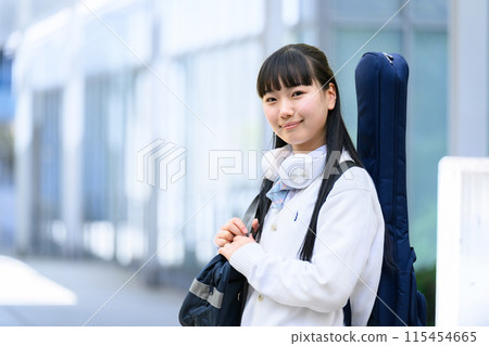 High school girl carrying a guitar 115454665
