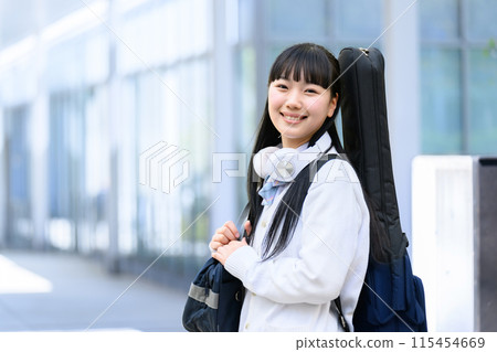 High school girl carrying a guitar 115454669