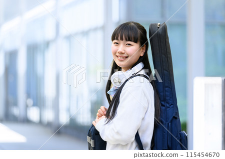 High school girl carrying a guitar 115454670