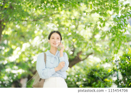 Businesswoman making a phone call among the fresh greenery 115454706