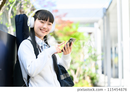High school girl carrying guitar, smartphone 115454876