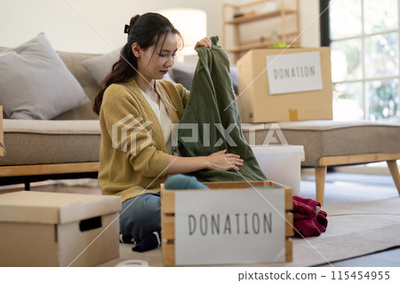 Volunteer Sorting and Donation Clothes for Charity in a Modern Living Room Setting, Highlighting Community Support and Generosity Volunteer Sorting and Donation Clothes for Charity in a Modern Living Room Setting, Highlighting Community Support and Generosity 115454955