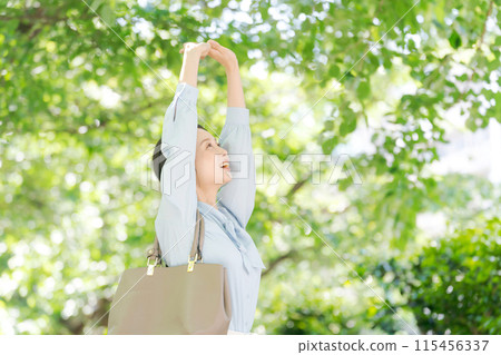 Business woman walking in fresh green 115456337