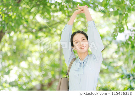 Business woman walking in fresh green Business woman walking in fresh green 115456338