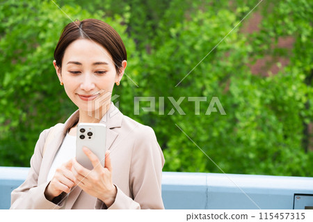 Young woman operating a smartphone Business image Young woman operating a smartphone Business image 115457315