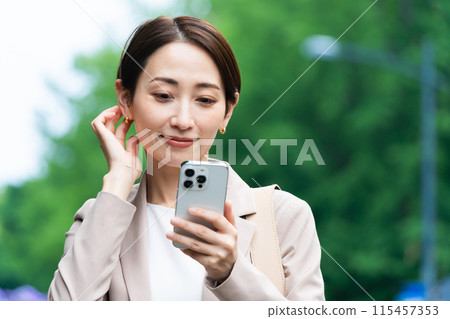 Young woman operating a smartphone Business image 115457353