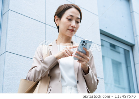 操作智慧型手機商業形象的年輕女性 操作智慧型手機商業形象的年輕女性 115457570