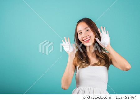 Portrait Asian young woman hands are adorned with white foam mousse studio shot isolated on blue background, beautiful female holds a cleansing foam near her face, Cosmetics beauty skincare 115458464