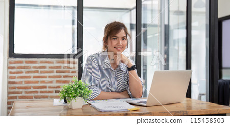 Confident Business Woman in Modern Office Setting, Professional and Successful, Working on Laptop, Smiling, Casual Attire, Bright Workspace, entrepreneur Spirit, Productivity and Ambition Confident Business Woman in Modern Office Setting, Professional and Successful, Working on Laptop, Smiling, Casual Attire, Bright Workspace, entrepreneur Spirit, Productivity and Ambition 115458503