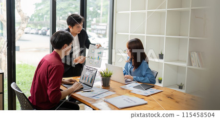 Business Team Discuss Analysis in Modern Office Setting with Charts and Laptops, Collaboration Work Environment, Professional Teamwork, Data Review, and Strategic Planning Business Team Discuss Analysis in Modern Office Setting with Charts and Laptops, Collaboration Work Environment, Professional Teamwork, Data Review, and Strategic Planning 115458504