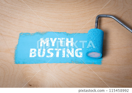 MYTH BUSTING. Blue paint and paint roller on a plywood background 115458992