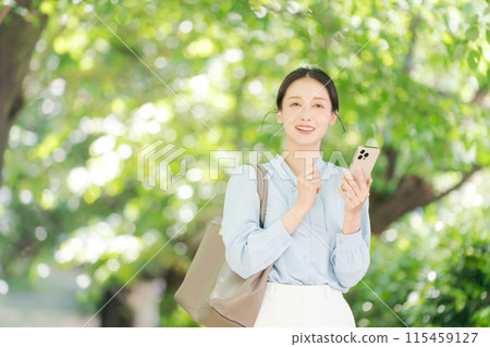 Businesswoman with smartphone in the park 115459127