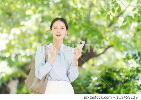 Businesswoman with smartphone in the park 115459129