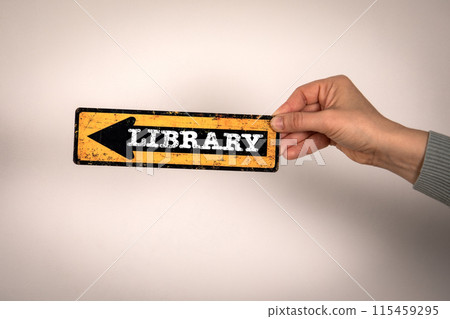 Library. Arrow with text in woman's hand on white background Library. Arrow with text in woman's hand on white background 115459295