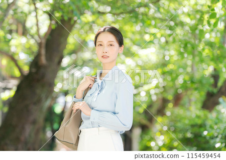 站在新鮮綠樹中的女人的肖像 站在新鮮綠樹中的女人的肖像 115459454