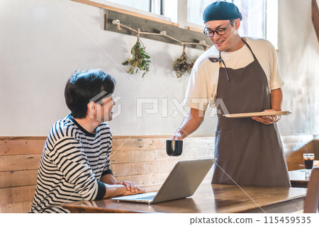 A cafe clerk, waiter and owner serving coffee and a male customer working remotely A cafe clerk, waiter and owner serving coffee and a male customer working remotely 115459535