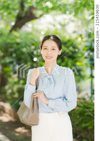 Portrait of a woman standing in fresh greenery 115459630