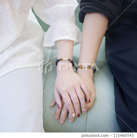 情侣佩戴着象征甜蜜爱情的情侣手链 情侣佩戴着象征甜蜜爱情的情侣手链 115460543