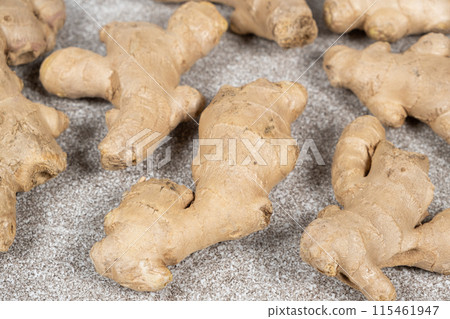 Fresh ginger roots on gray stone background close-up. Fresh ginger roots on gray stone background close-up. 115461947