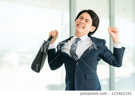 A young Asian male businessman in a suit stretching after work (stiff shoulders, fatigue, lack of exercise) A young Asian male businessman in a suit stretching after work (stiff shoulders, fatigue, lack of exercise) 115462191