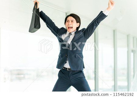 A young Asian male businessman in a suit doing a banzai (success, happiness, quota, achievement, fulfillment, results, results) A young Asian male businessman in a suit doing a banzai (success, happiness, quota, achievement, fulfillment, results, results) 115462192