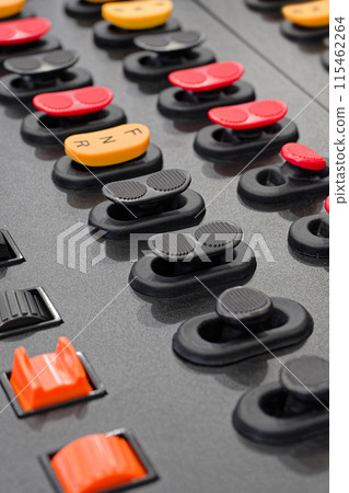 Black control panel with accorted buttons and switches 115462264