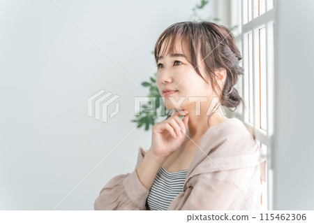 Asian woman thinking and worrying while resting her chin on her hands (beauty/diet) 115462306