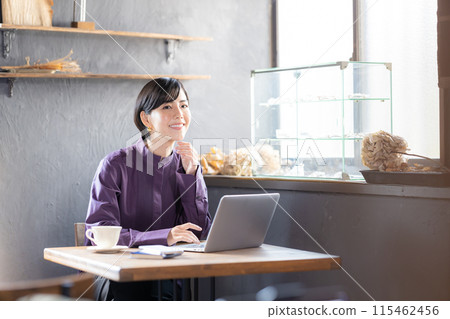 Woman looking at a laptop in a cafe 115462456