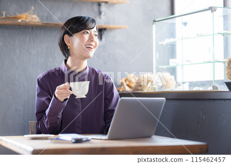 Woman looking at a laptop in a cafe Woman looking at a laptop in a cafe 115462457