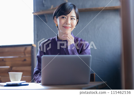 Woman looking at a laptop in a cafe Woman looking at a laptop in a cafe 115462536