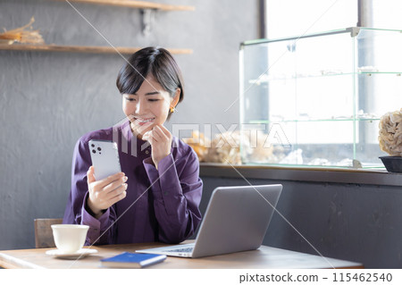 Woman looking at a laptop in a cafe 115462540
