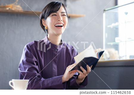 Woman reading a book in a cafe Woman reading a book in a cafe 115462638