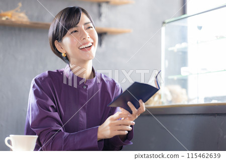 Woman reading a book in a cafe 115462639