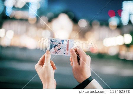 A couple taking a photo in the city at night 115462878