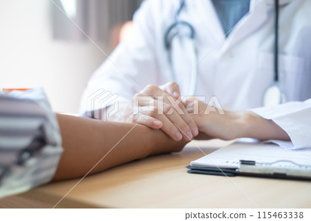 The female doctor uses a friendly hand to hold the patient's hand to give confidence and show care about health care. Medical concepts and good health 115463338