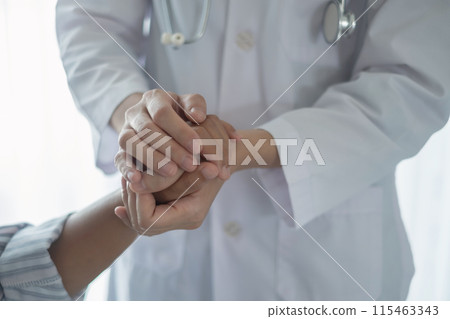 The female doctor uses a friendly hand to hold the patient's hand to give confidence and show care about health care. Medical concepts and good health 115463343