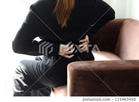 Woman having back body pain during work long time. stretching to relax and relax while working hard at the office 115463450