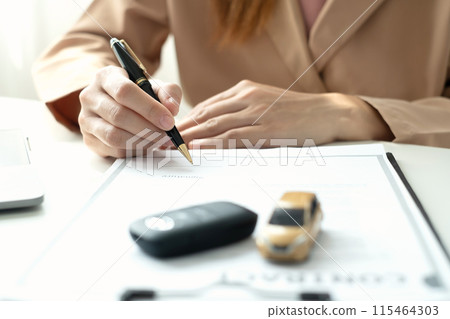 Car dealer businesswoman signing car insurance document or lease paper. Car loan and insurance concept 115464303