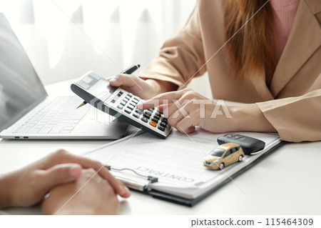 The car dealer advises the customer about insurance details and car rental information Ready delivers the keys after signing the rental contract The car dealer advises the customer about insurance details and car rental information Ready delivers the keys after signing the rental contract 115464309