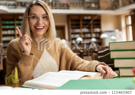 Blonde young woman studying in the library Blonde young woman studying in the library 115465907