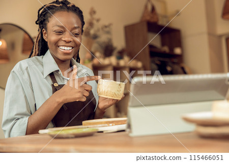 Smiling female sculptor holding a new mug in hands 115466051